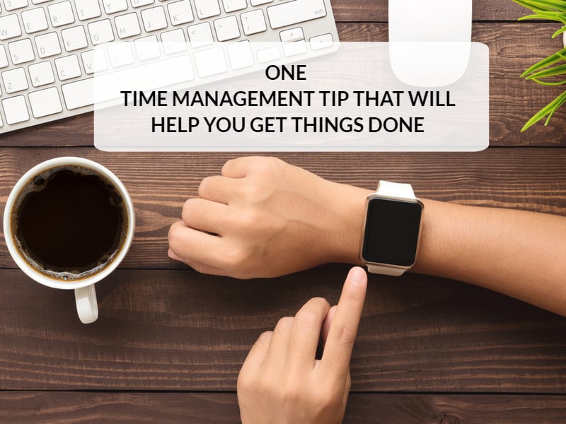 Person wearing watch on hand against table and coffee cup