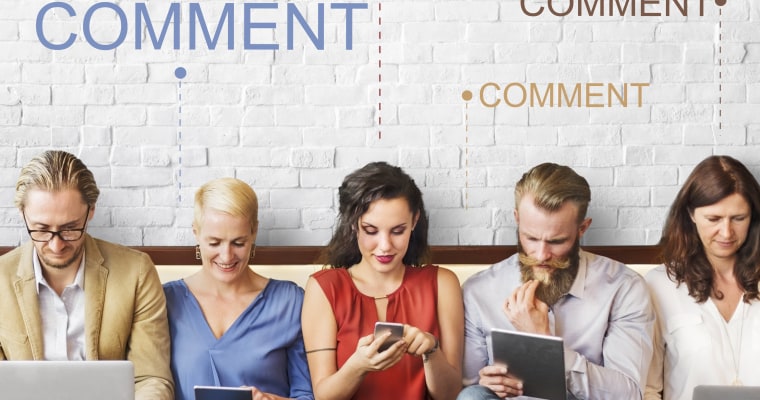 People seated next to each other looking at their devices